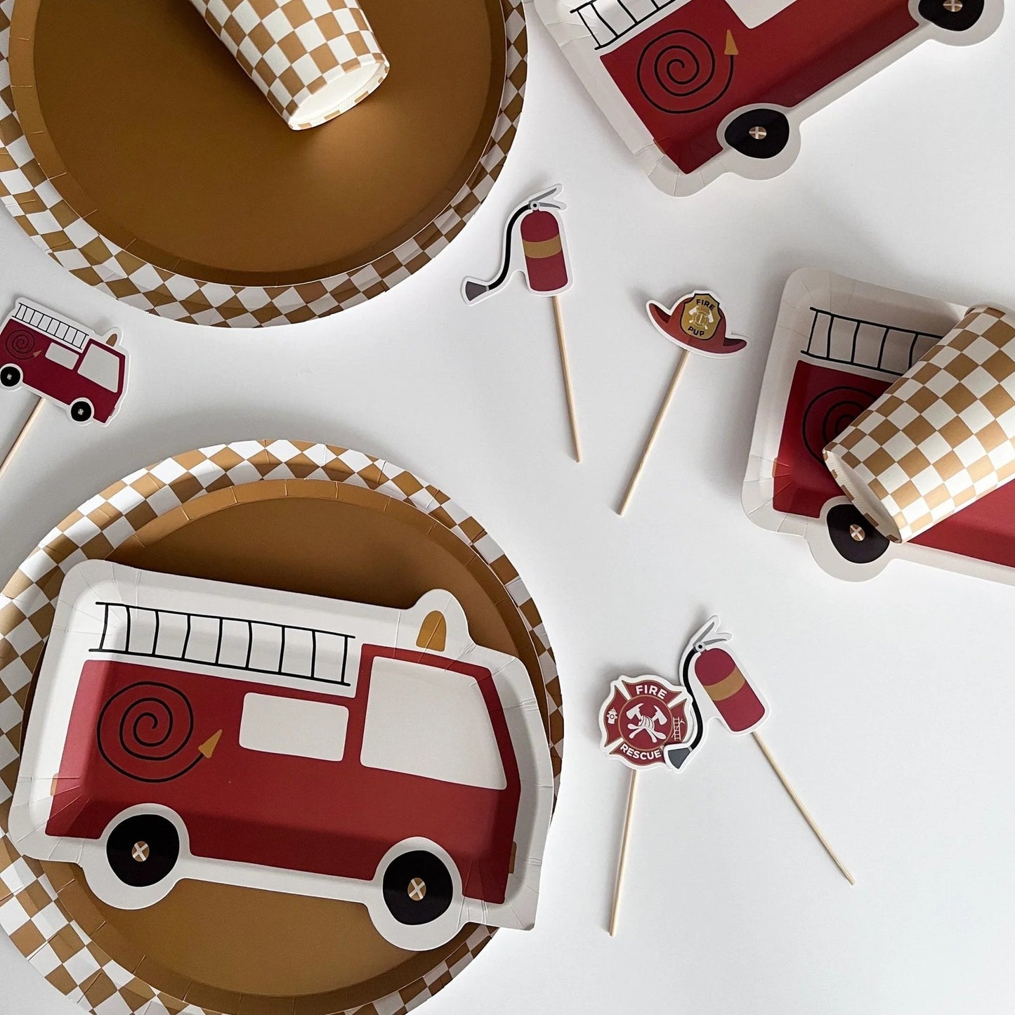 Fire truck-themed paper plates and flags on a white background