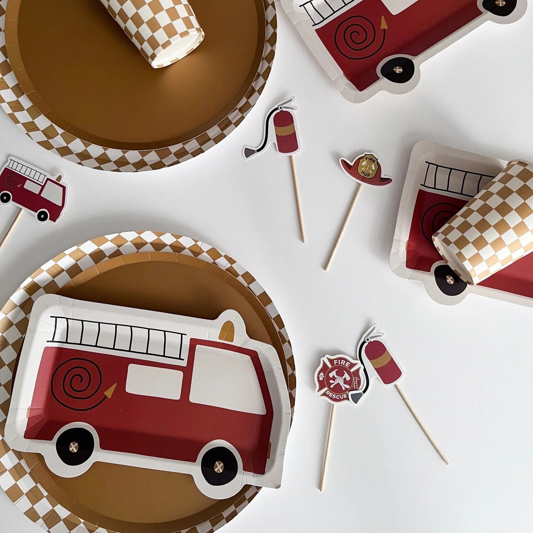 Fire truck-themed paper plates and flags on a white background