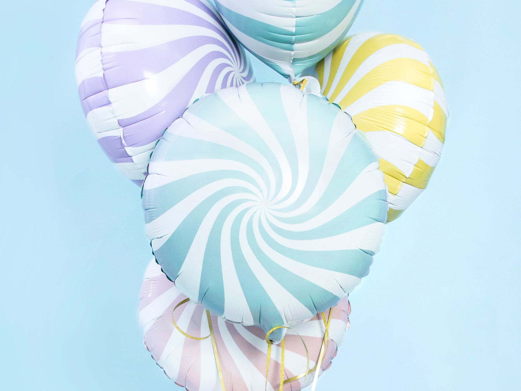 Colorful spiral-patterned balloons on a light blue background