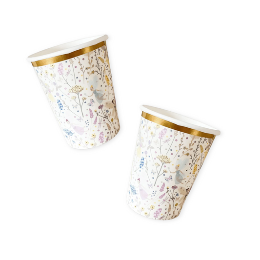 Two paper cups with floral and fairy design on a white background
