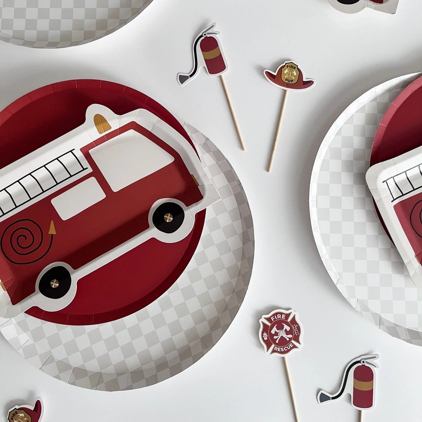 Fire truck-themed paper plates and cutouts on a white background