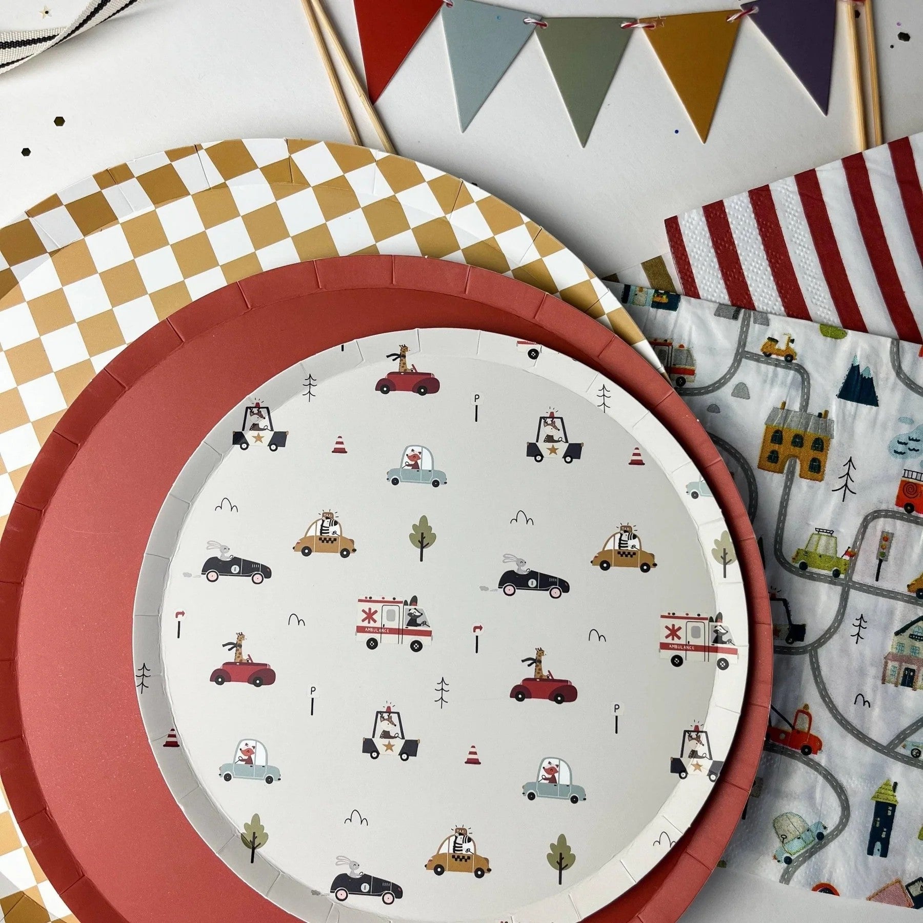 Children's party tableware with patterned plates on a white surface.