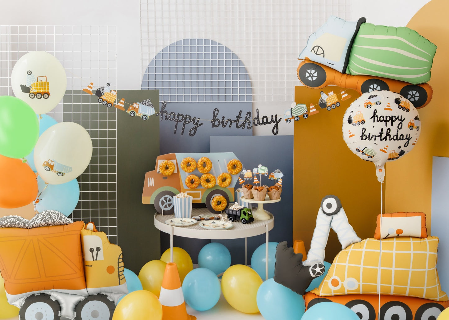 Birthday party setup with balloons, cake, and decorative elements on a table.