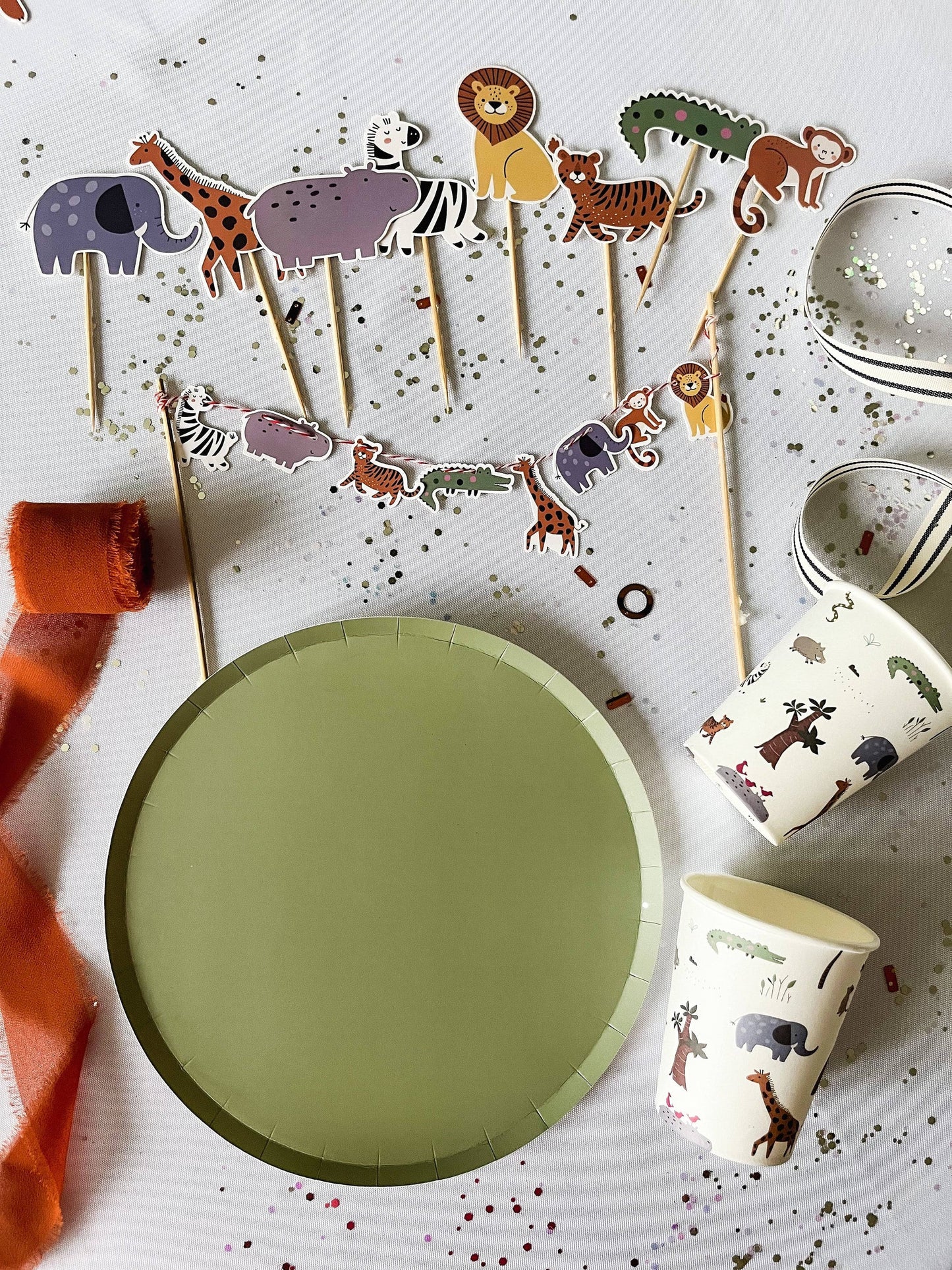 Children's party supplies with animal-themed decorations on a white surface