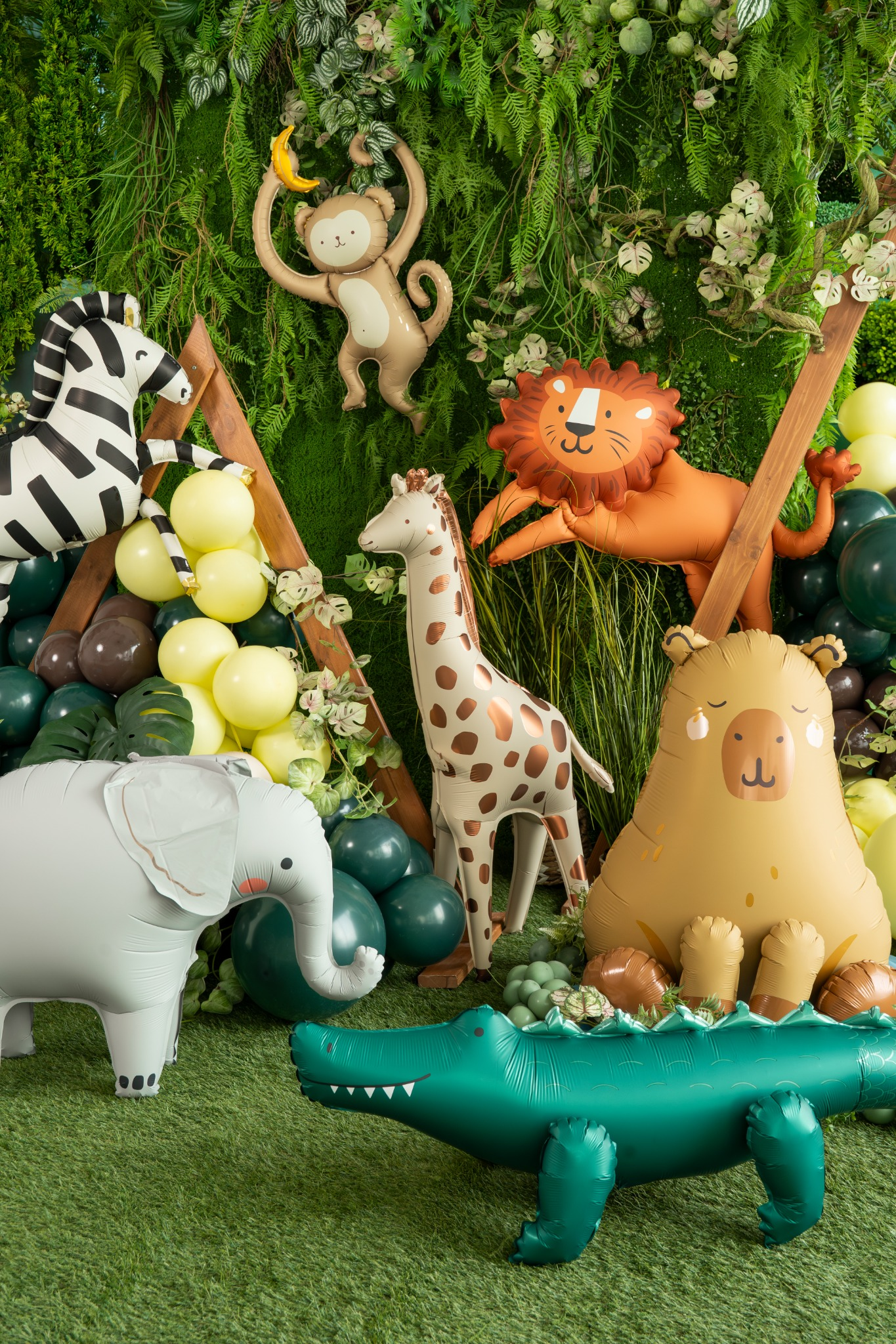 Collection of inflatable animal toys on a green grass-like surface with a forest background.