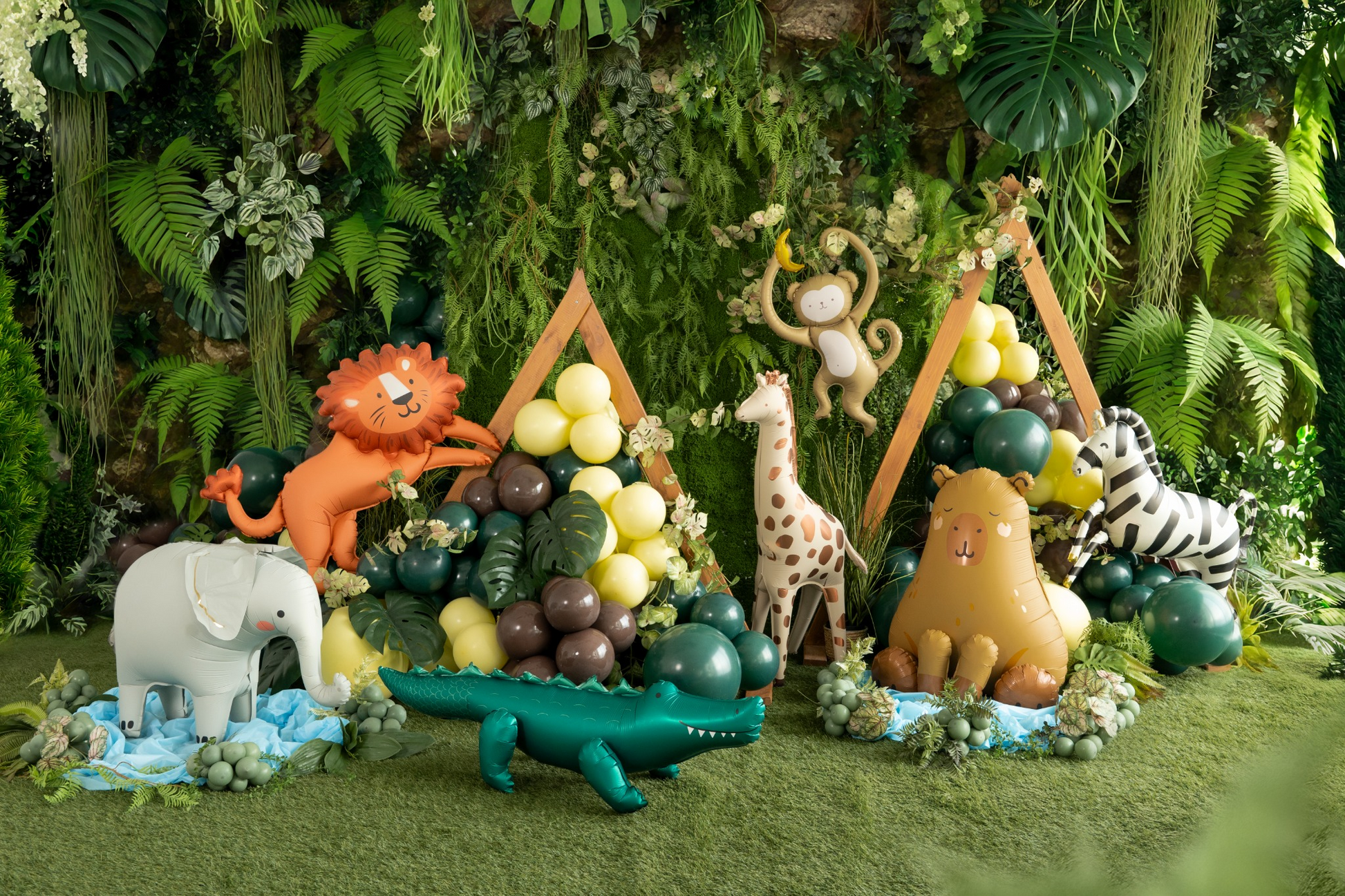 Balloon animals and structures on a grassy area with plants and flowers